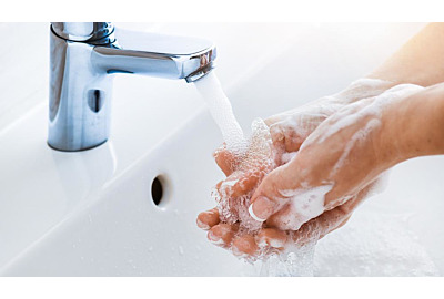 Woman use soap and washing hands under the water tap. Hygiene concept hand detail.