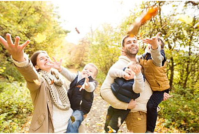 Schöne junge Familie auf einem Spaziergang im Herbstwald.